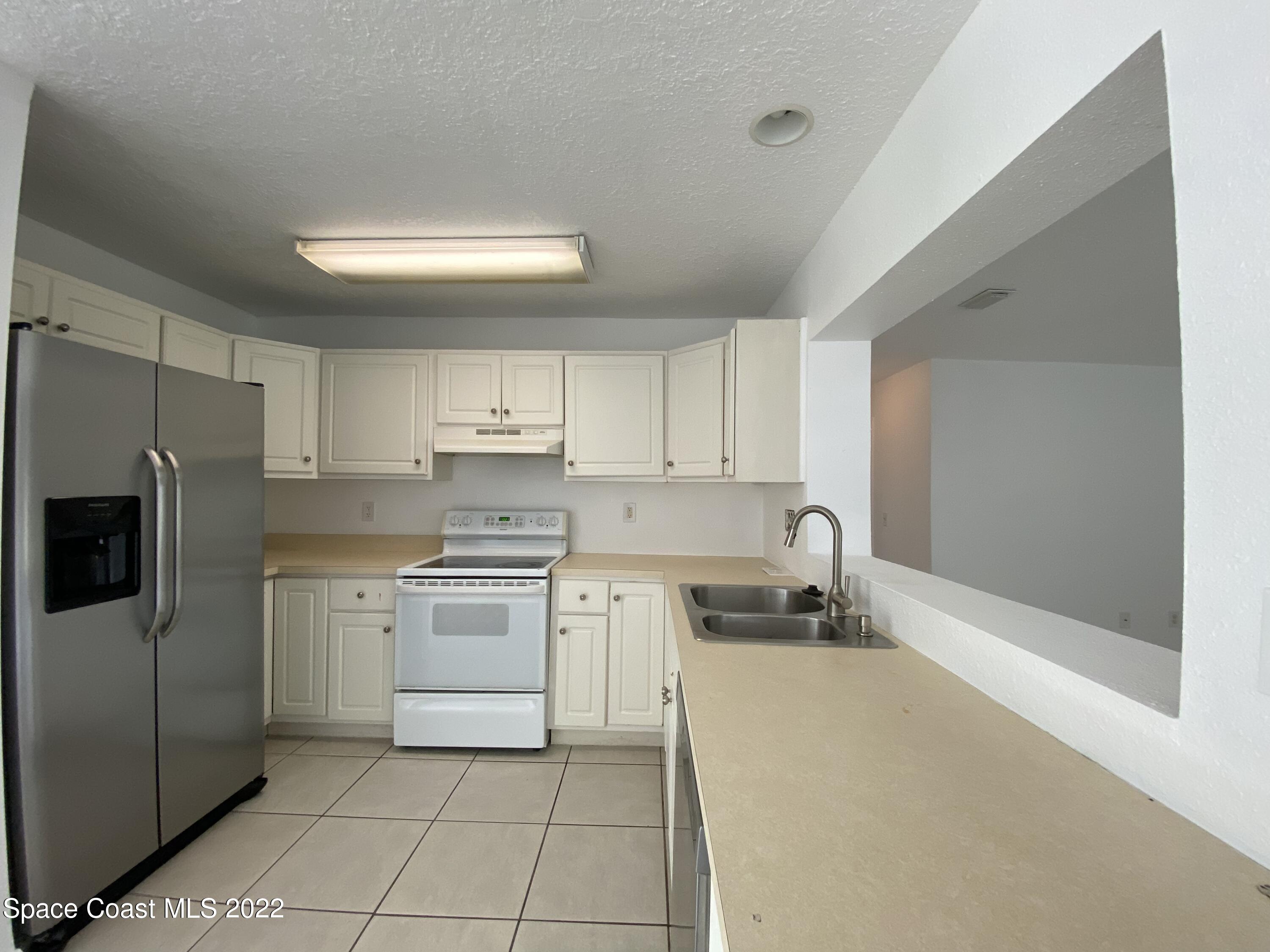 4120 Duke Street Melbourne, FL 32901 - Photo 37 of 49 a kitchen with a stove a sink and a refrigerator