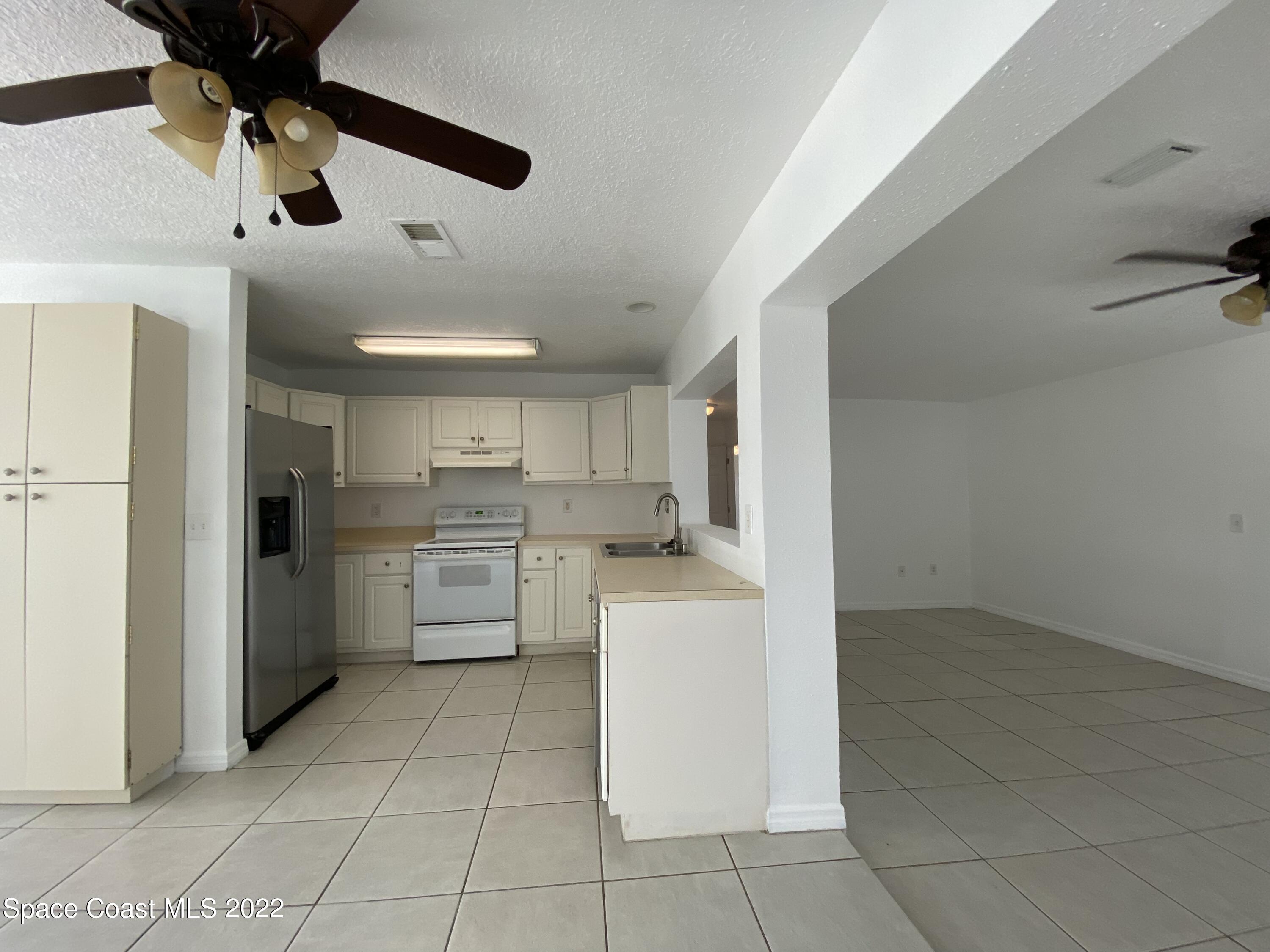 4120 Duke Street Melbourne, FL 32901 - Photo 39 of 49 a kitchen with a stove a refrigerator and a sink