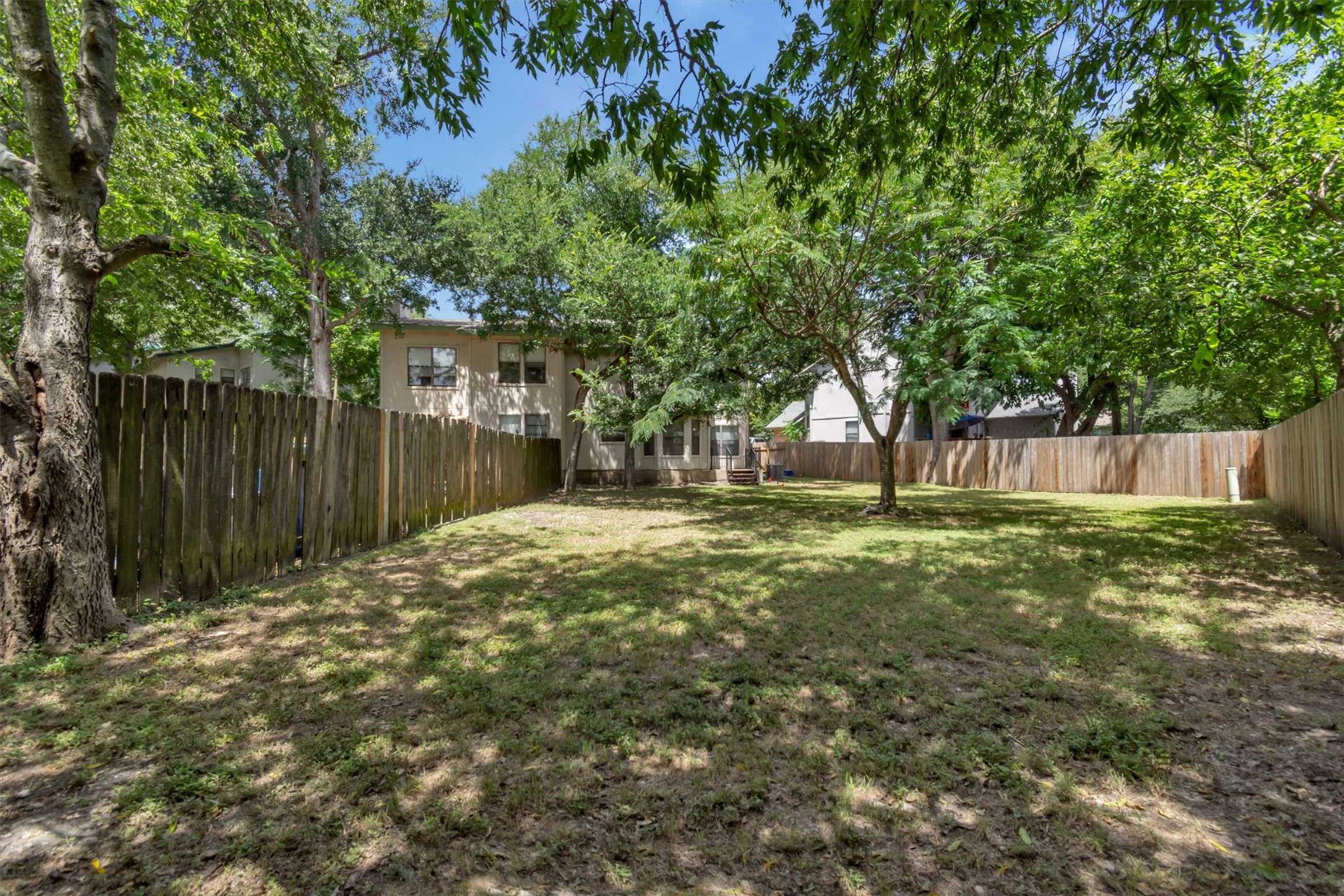 7802 Topawa Cove, Unit B Austin, TX 78729 - Photo 26 of 32 A spacious yard, perfect for outdoor activities and relaxation, with a privacy fence surrounding the property.