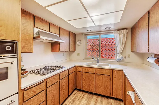 a kitchen with stainless steel appliances a sink stove and cabinets