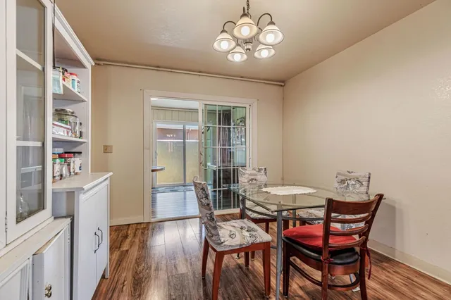 a view of a dining room with furniture wooden floor and a chandelier