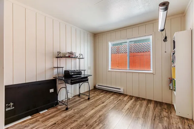 a view of a room with a window and wooden floor