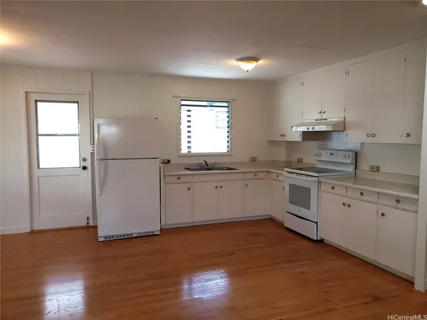 a kitchen with granite countertop white cabinets and white appliances