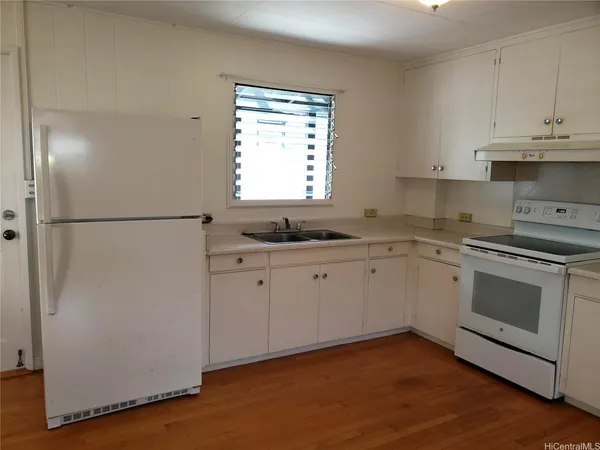 a kitchen with granite countertop white cabinets and white appliances
