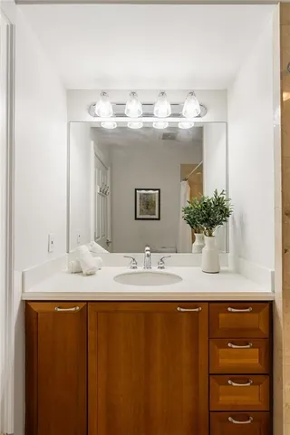a bathroom with a granite countertop sink and a mirror