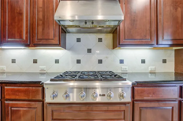 an empty room with chandelier fan and windows