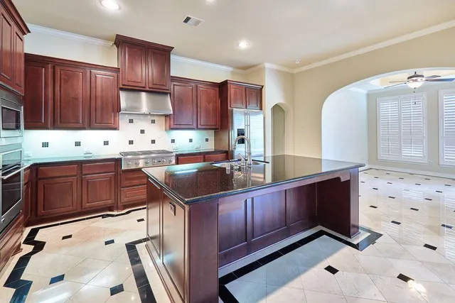 a kitchen with stainless steel appliances granite countertop a sink stove and cabinets