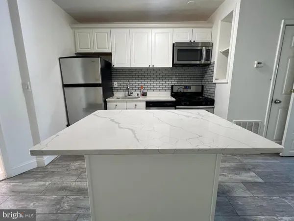 a kitchen with a refrigerator a microwave a sink and cabinets