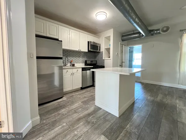 a kitchen with stainless steel appliances granite countertop a refrigerator a stove top oven a sink and dishwasher