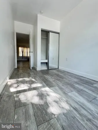 a view of a hallway with wooden floor and a living room