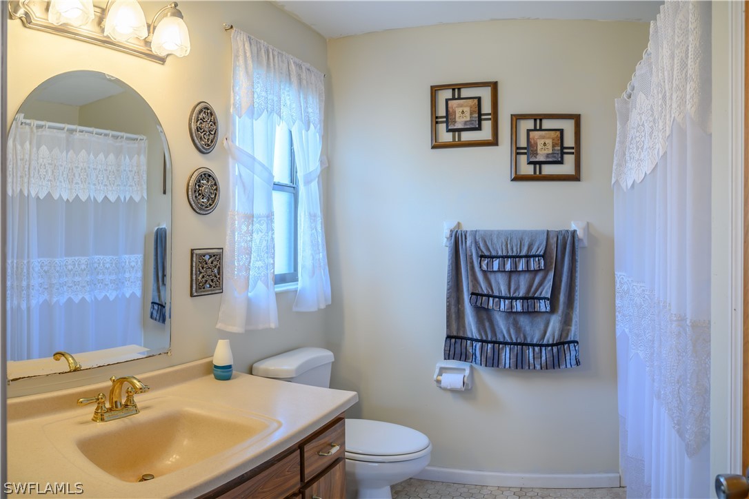 18430 Hepatica Road Fort Myers, FL 33967 - Photo 9 of 16 a bathroom with a toilet sink and mirror