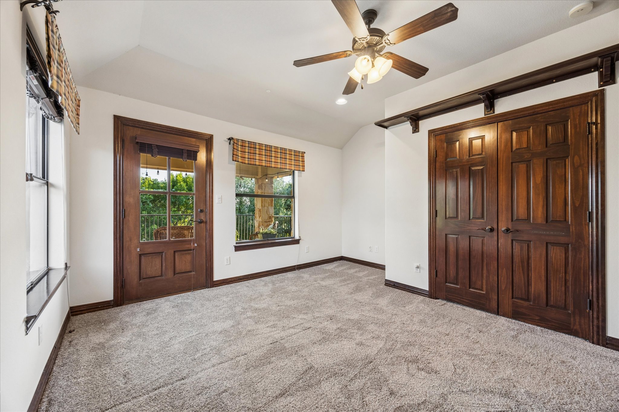 11805 Ranchview Court Austin, TX 78732 - Photo 27 of 36 Interior room featuring plush carpeting, a ceiling fan with integrated lighting, and multiple windows with patterned roman shades
