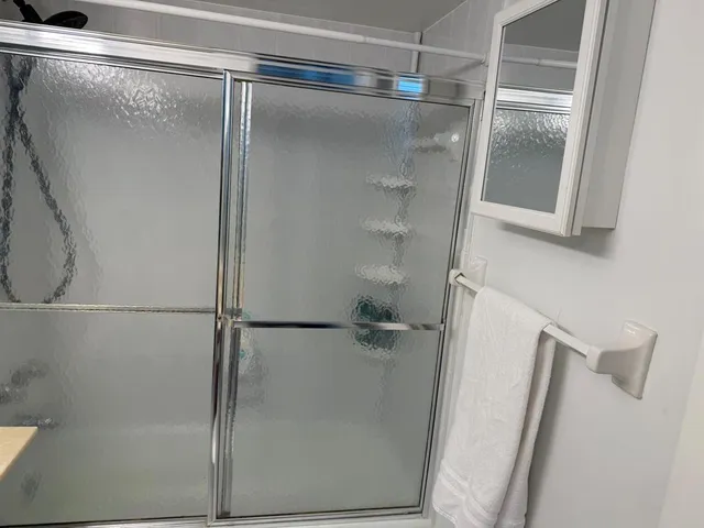 a bathroom with a glass shower door
