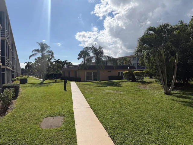 a view of a fountain in front of a house with a big yard