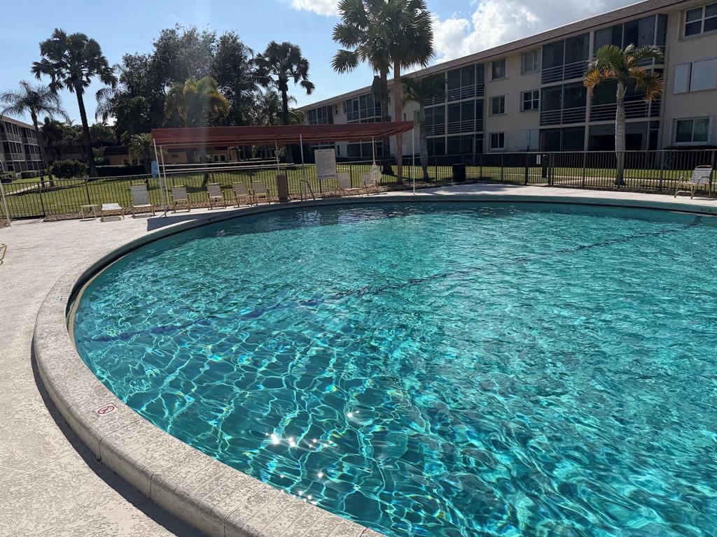 4502 North Federal Highway, Unit 235D Lighthouse Point, FL 33064 - Photo 30 of 40 a view of a swimming pool with a garden and trees