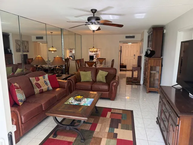 a living room with furniture a flat screen tv and a table