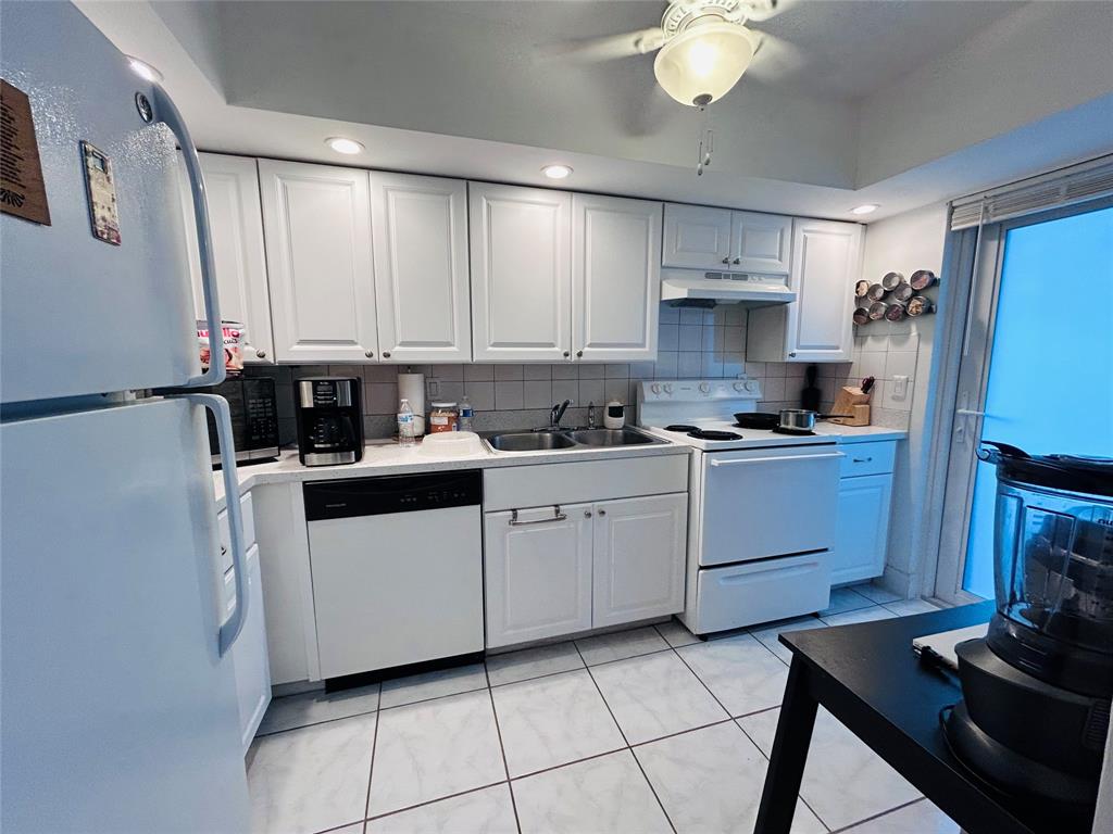 4502 North Federal Highway, Unit 235D Lighthouse Point, FL 33064 - Photo 7 of 40 a kitchen with a refrigerator a stove a sink cabinets and a dining table