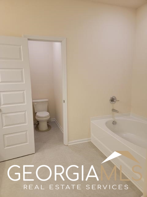 160 Madison Bend Holly Springs, GA 30188 - Photo 14 of 18 a bathroom with a toilet a sink and a bathtub