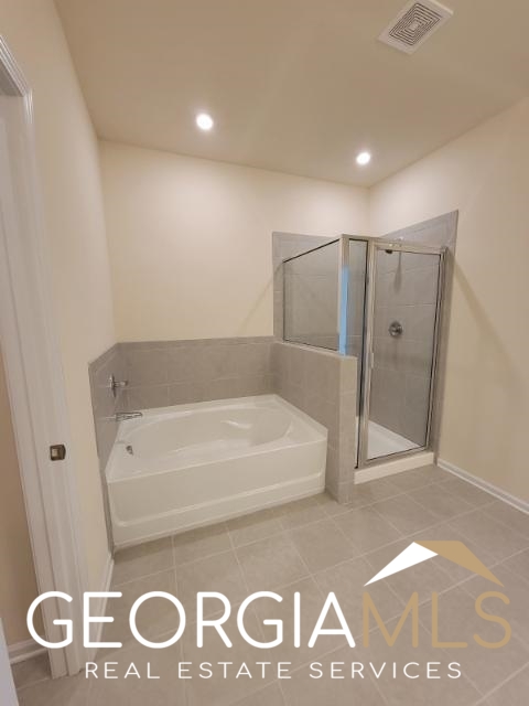 160 Madison Bend Holly Springs, GA 30188 - Photo 15 of 18 a bathroom with a tub and a shower