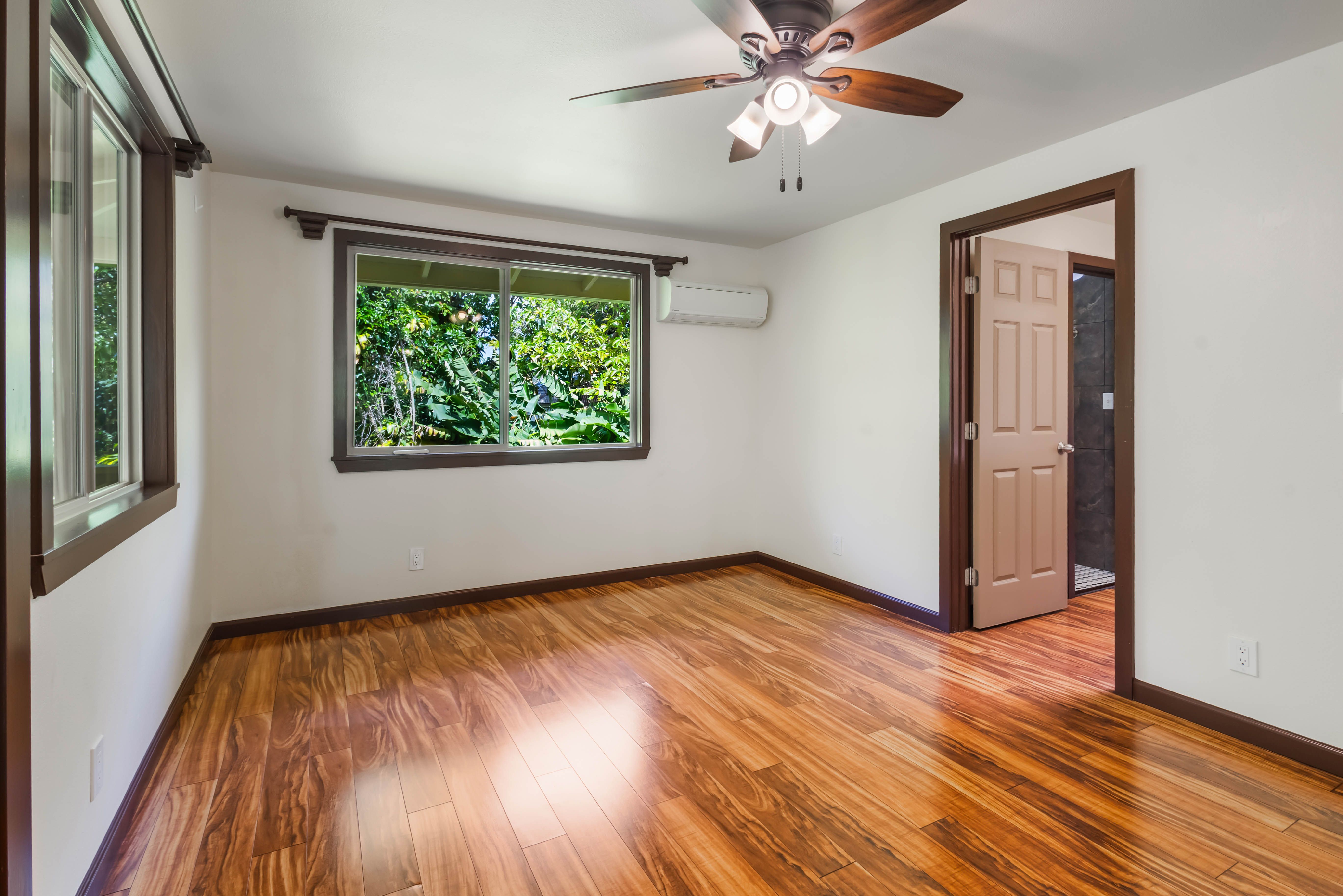 4085 B Noho Road Koloa, HI 96756 - Photo 16 of 30 an empty room with wooden floor chandelier fan and windows
