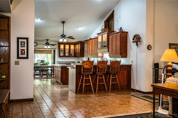 a kitchen with stainless steel appliances granite countertop a sink a stove cabinets and a dining table