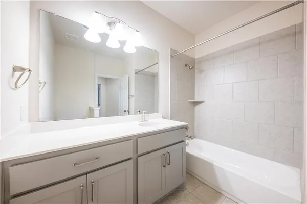 a bathroom with a sink a large mirror and a bathtub