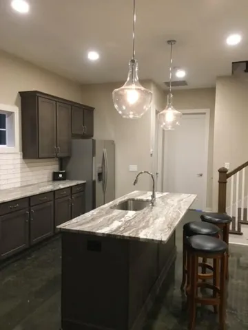 a kitchen with a kitchen island hardwood floor sink stove dining table and chairs