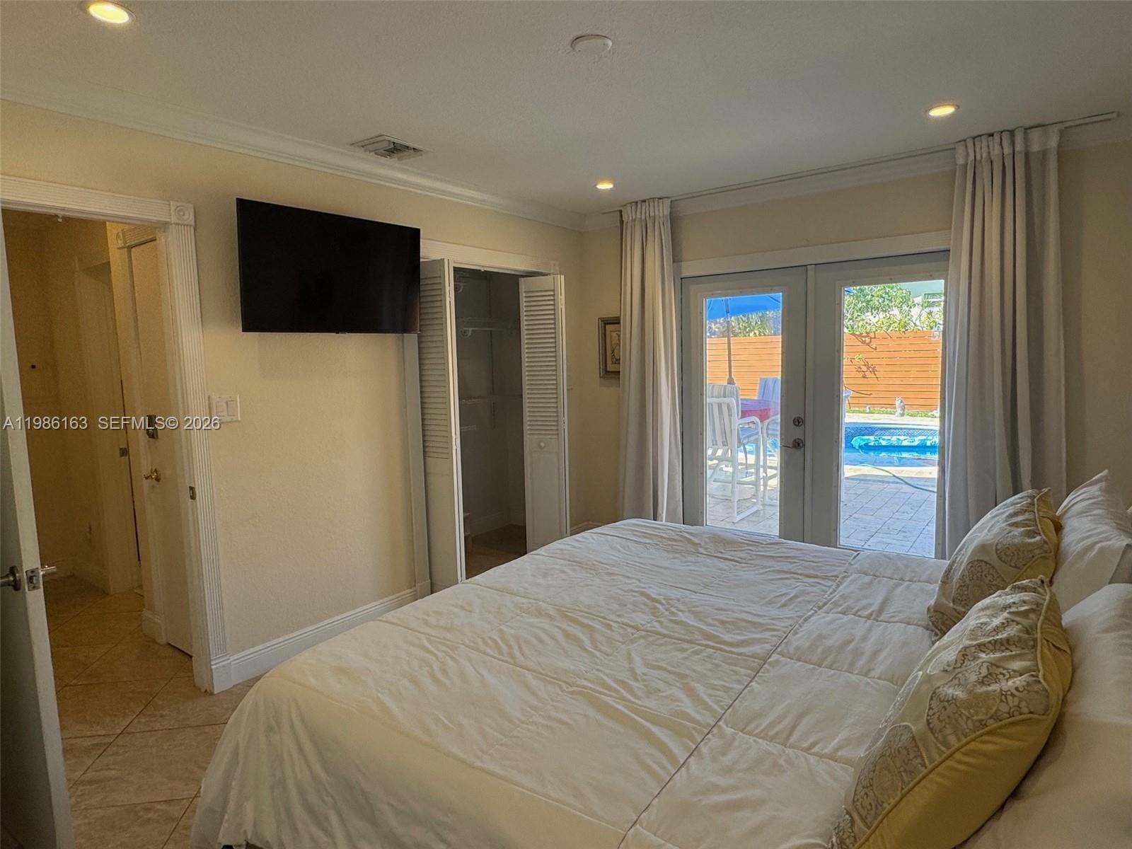2355 Southeast 7th Street Pompano Beach, FL 33062 - Photo 19 of 31 a bedroom with a bed and a large mirror