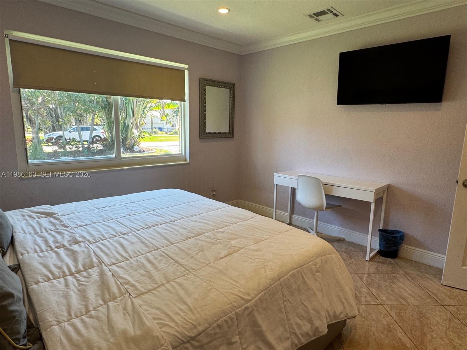 2355 Southeast 7th Street Pompano Beach, FL 33062 - Photo 23 of 31 a bedroom with a bed a flat screen tv and a window