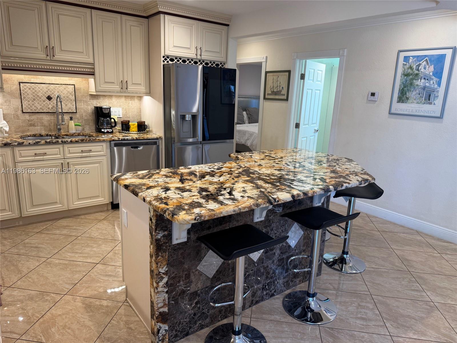 2355 Southeast 7th Street Pompano Beach, FL 33062 - Photo 8 of 31 a kitchen with stainless steel appliances kitchen island granite countertop a table chairs and cabinets