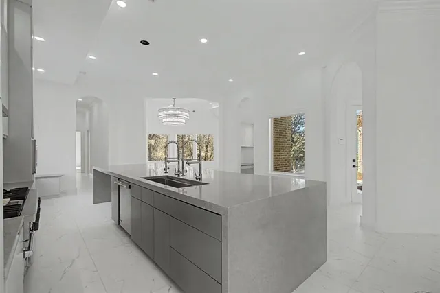 a kitchen with stainless steel appliances granite countertop a sink and a stove top oven