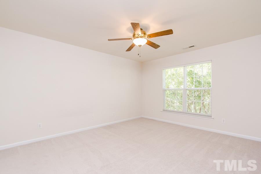 5445 Brandy Bay Road Raleigh, NC 27613 - Photo 22 of 25 an empty room with a window and a ceiling fan