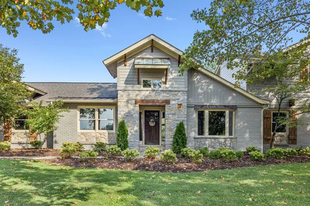 a living room with furniture large window and wooden floor