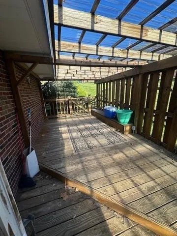 a view of an empty room with wooden floor and fan