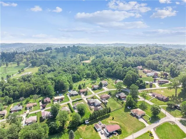 an aerial view of residential houses with outdoor space and street view
