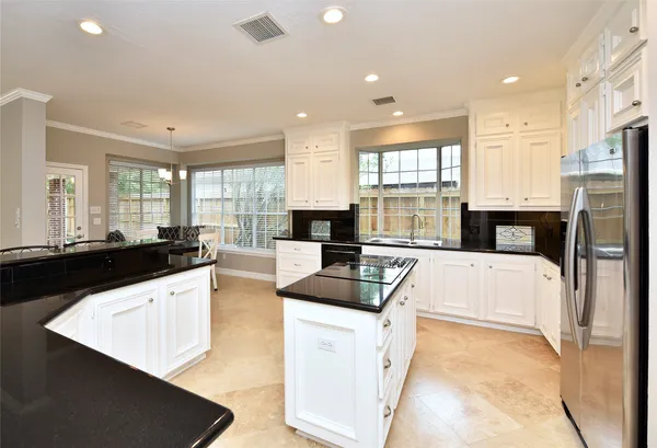 a kitchen with granite countertop a sink stainless steel appliances and cabinets