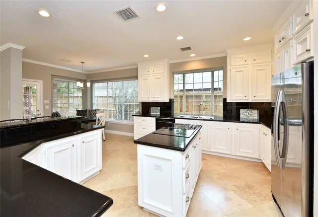 a kitchen with granite countertop a sink stainless steel appliances and cabinets