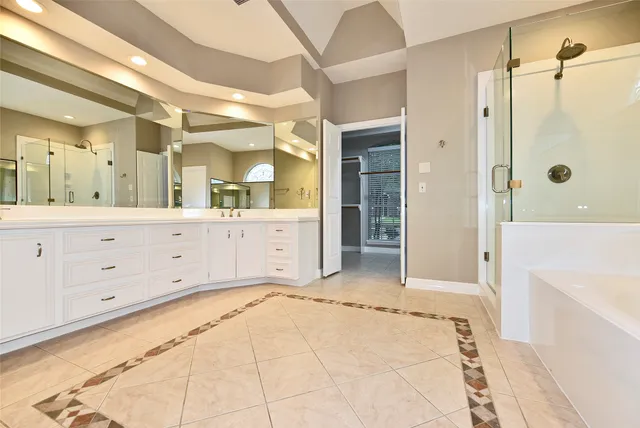 a spacious bathroom with a bathtub sink and mirror