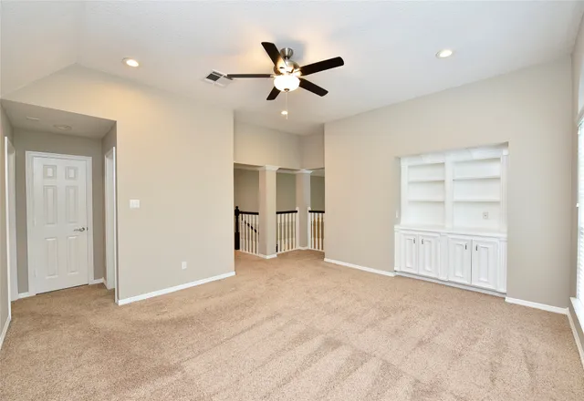 an empty room with closet and a chandelier fan