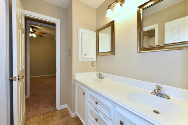 an empty room with chandelier fan and windows