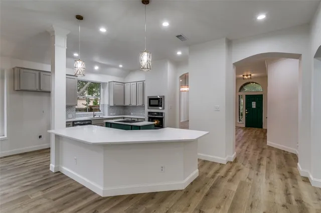 a large kitchen with stainless steel appliances granite countertop a large stove a sink and a refrigerator