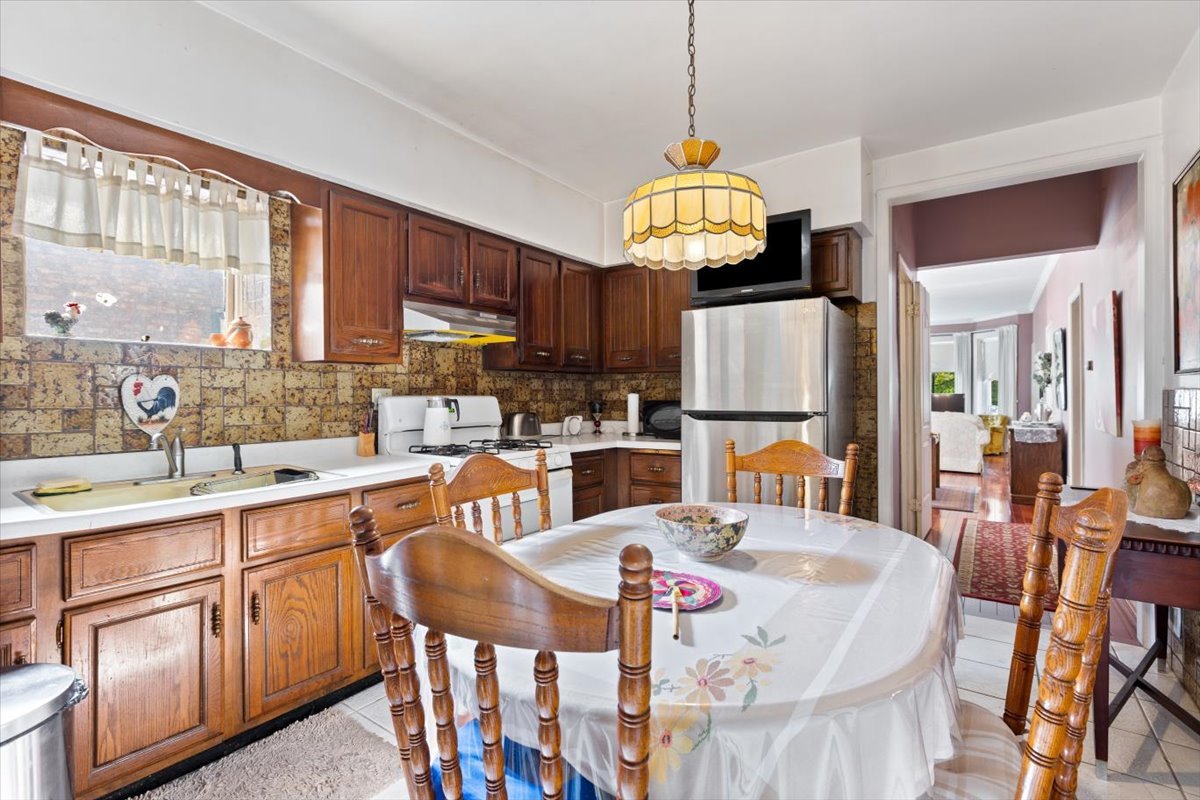 3911 North Kedzie Avenue Chicago, IL 60618 - Photo 17 of 35 a open kitchen with stainless steel appliances granite countertop a stove top oven a refrigerator a sink dishwasher a dining table and chairs with wooden floor