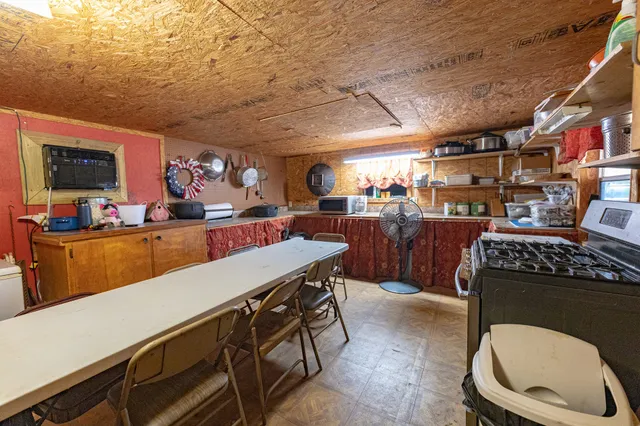 a kitchen with a stove a cabinets and a dining table
