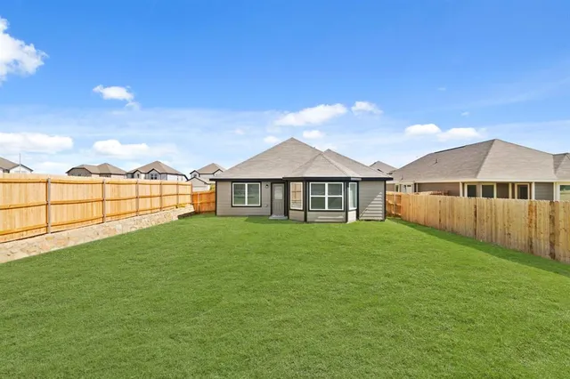 a view of a yard with a house in the background