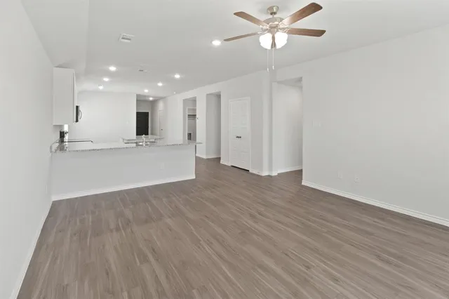 a view of a kitchen with wooden floor and a ceiling fan