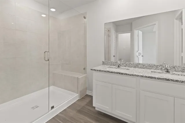 a bathroom with a granite countertop sink a mirror and a bathtub