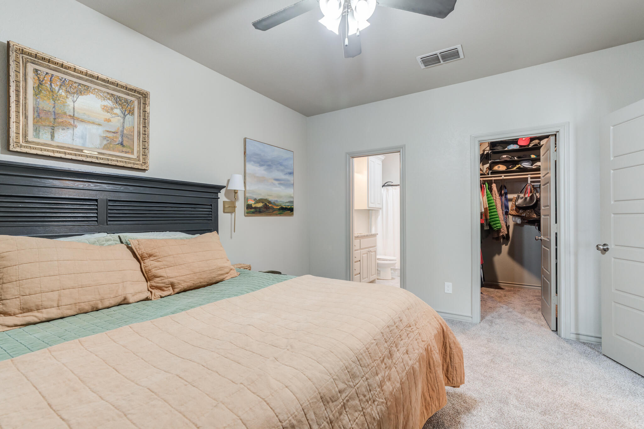 7813 88th Street Lubbock, TX 79424 - Photo 12 of 21 a bedroom with a large bed and a chandelier