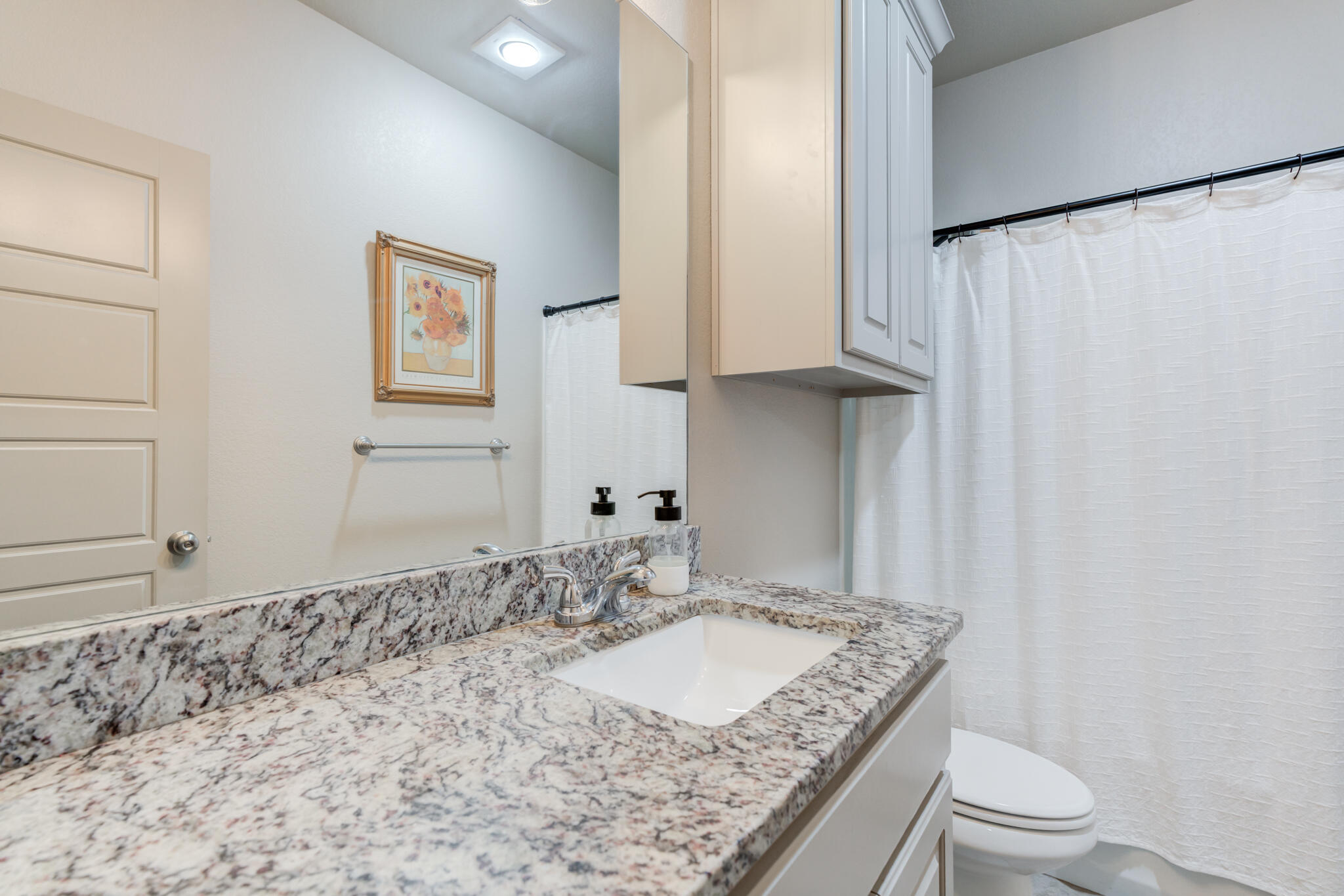 7813 88th Street Lubbock, TX 79424 - Photo 13 of 21 a bathroom with a granite countertop sink a toilet and a mirror