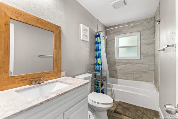 a bathroom with a granite countertop toilet sink and bathtub