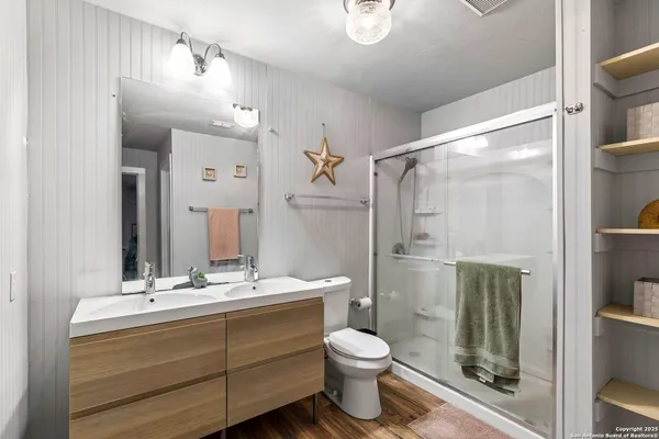 a bathroom with a double vanity sink toilet and shower